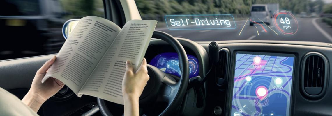 Person liest in einem selbstfahrenden Auto - Digitale Transformation